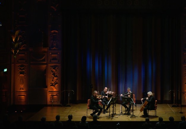 Four musicians playing. Photo.