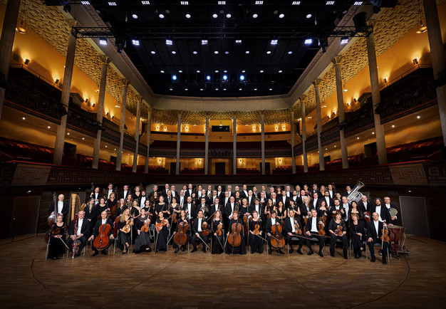 Orchestra lined up on the podium. Photography.