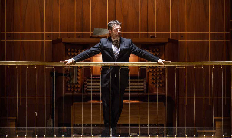  Man standing in front of the organ´s keyboard. Photo.