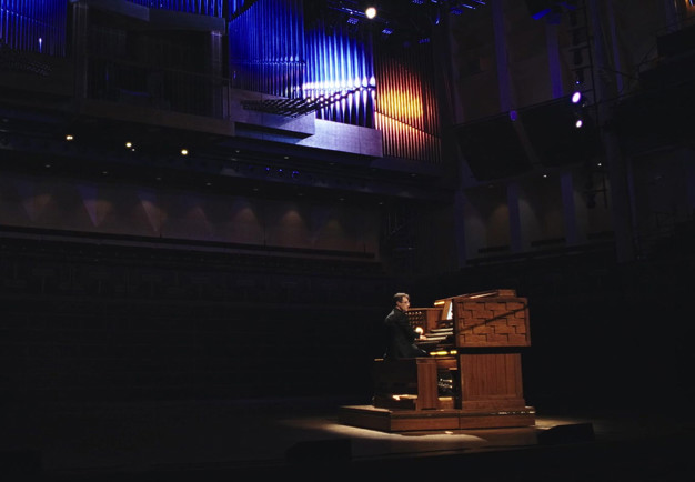 Man som spelar orgel. Fotografi.