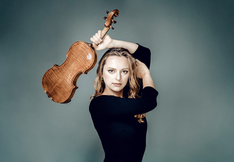 Kvinna som håller i en violin. Fotografi