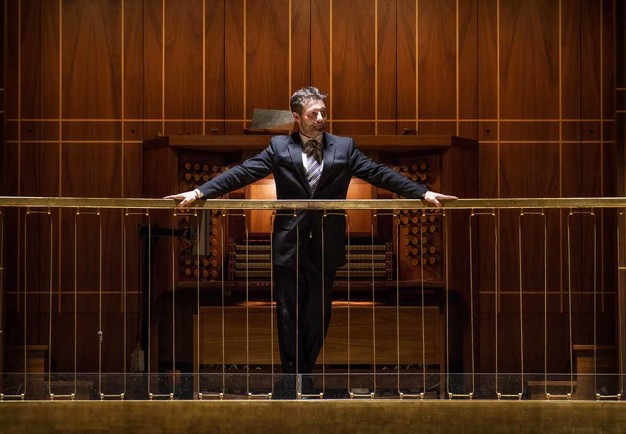  Man standing in front of the organ´s keyboard. Photo.